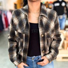 Jaqueta feminina Giada xadrez em tons de marrom, bege e preto com botões frontais, usada com blusa preta e jeans azul