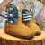 Bota Texana Infantil Hellaza nas cores caramelo e azul, com detalhes em estrelas brancas e listras. Ideal para crianças.