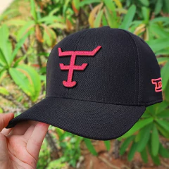 Boné Texas Farm preto com detalhes em rosa neon, exibido em meio à vegetação.