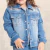 Jaqueta infantil de jeans azul, estilo western, com detalhes em bordado e botões frontais, usada por uma criança.