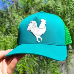 Boné trucker na cor turquesa com estampa de um galo em relevo.