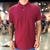 Modelo usando uma polo masculina Acostamento Bali na cor vinho, com detalhes em botão e logo bordado.