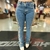 Calça feminina bootcut da marca Buphallos, com detalhes bordados nas laterais, em jeans claro.