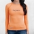 Camiseta térmica feminina laranja com proteção UV50+, da marca Texas Farm, destacando o logotipo frontal.