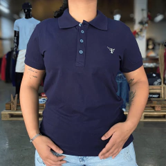 Polo Texas Farm Feminina New Style Cpf011 na cor azul marinho, com botões frontais e logo bordado no peito, vestida por uma mulher.