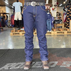 Homem vestindo calça jeans reta masculina Pura Raça Stone, com cinto e botas, em loja de roupas masculinas.