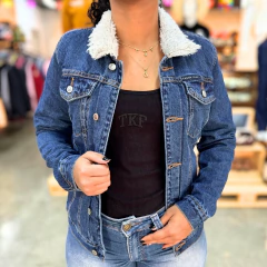 Jaqueta jeans feminina com gola de pelúcia, usada por mulher em ambiente casual.