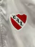 Detalle del logo del Club Atlético Independiente en una rompeviento blanca.