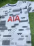 Camiseta del Tottenham con diseño moderno, color blanco y detalles en gris, con el logo de Nike y la palabra AIA en rojo.