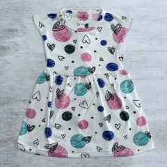 Vestido para bebas con estampado de círculos y corazones en colores pastel sobre fondo blanco.