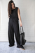 Pantalón Milos de SAHA, color negro, con una modelo que lleva una blusa sin mangas y un bolso negro.