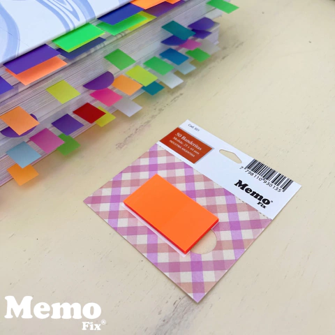 Banderitas autoadhesivas MemoFix color naranja tamaño 24x45mm sobre un paquete con diseño cuadriculado y libro con marcadores de colores