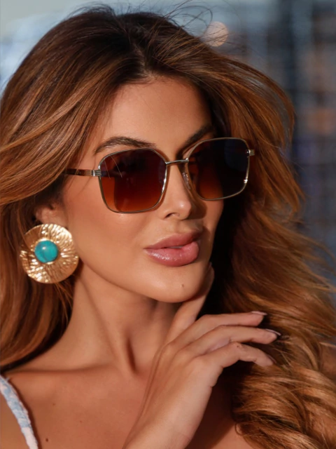 Óculos de Sol Ruan marrom degradê com haste dourada em metal premium. Proteção UV400 e lente resistente. Revenda entre R$59,90-R$199,90. Compre no atacado Clush!