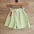 Short verde claro para niñas con cintura elástica y bolsillos.