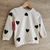 Buzo blanco con estampados de corazones negros.