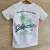 Remera blanca  con diseño de palmeras y texto que dice "California"