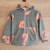 Campera de plush con estampado de capibaras comiendo helados y paletas, con capucha y cierre frontal.