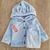 Conjunto de polar soft para bebés, compuesto por campera con capucha y pantalones, con orejas y botones de madera.