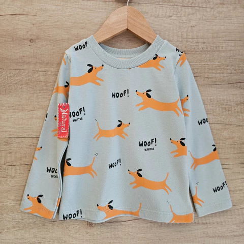 Remera infantil azul celeste con estampado de perros naranjas y texto "WOOF!"