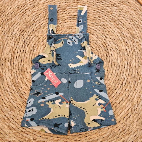 Jardinero corto para bebé con estampa de dinosaurios en tonos azules y beige, con botones en los tirantes y bolsillos frontales