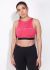 Top deportivo fucsia de mujer con diseño de logo en el frente y espalda cruzada. 