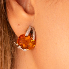 Brinco de citrino em ouro branco 18k, destacando a pedra laranja e detalhes em diamante.