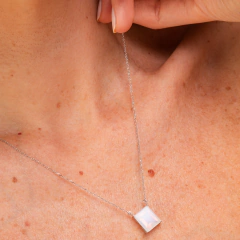 Escapulário Elisabete Gaspar em colar prateado com pendente retangular, destacado no pescoço de uma pessoa.