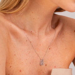 Escapulário Elisabete Gaspar em colar prateado, usado por mulher com pele clara e sardas.