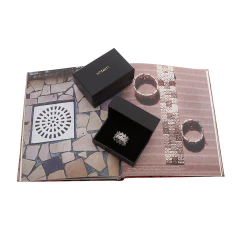 Anel H. Stern Irmãos Campana em caixa preta aberta sobre livro aberto com imagens de mosaico