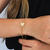Pulseira Coração Cravejado banhada a ouro 18K no pulso.