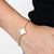 Pulseira Trevo Branco banhada a ouro 18K, destacando o design delicado e elegante.