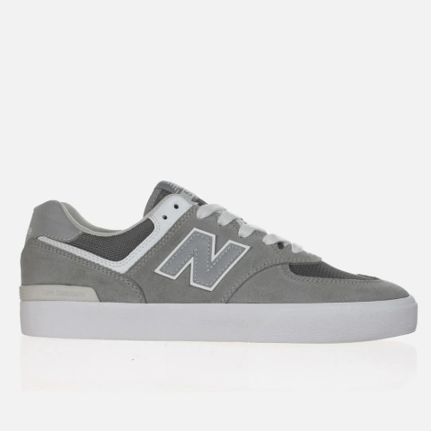 Tênis New Balance 574 Cinza em exibição lateral com detalhes em branco e cinza.