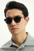 Homem usando óculos de sol redondo modelo Duna Tortoise Havana, com armação em tom havana e lentes escuras.