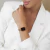 Woman wearing a Women's Square Watch Nolita Black Rose Gold on her wrist, dressed in a white blazer.