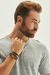 Pulseira masculina de couro trançado marrom com fecho magnético no pulso de um homem.