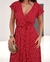 Vestido envelope midi vermelho com estampa de poá, detalhes em mangas curtas e cinto na cintura.