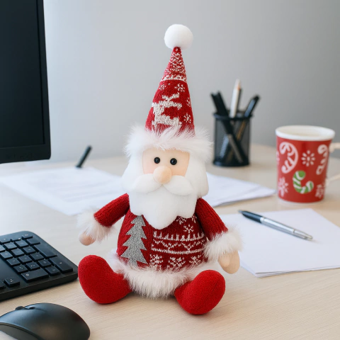 Muñeco de papá Noel sentado de 30 cm con gorro rojo y detalles navideños sobre un escritorio de oficina