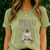 Pistache - T-Shirt Feminina Nirvana Figura Sentada Grunge com Símbolos Abstratos Tons Terrosos