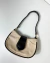 Bolsa vintage creme com detalhes em preto.
