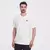 Camiseta New Balance 550 color creme, modelo masculino, com logotipo impresso no peito.
