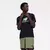Camiseta preta da New Balance com logo em destaque, modelo masculino posando de forma casual.