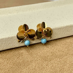 BRINCO FLOR PINGO AZUL PEQUENO DOURADO na internet