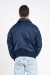 homem vestindo jaqueta bomber azul marinho com bolsos frontais e patches da NASA e das missões Apollo
