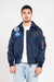 homem vestindo jaqueta bomber azul marinho com bolsos frontais e patches da NASA e das missões Apollo