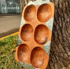 Tabla de madera con divisiones de alpaca, ideal para picadas, mostrando seis compartimentos redondeados y alpaca a los bordes