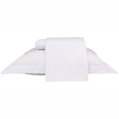 Jogo de lençol solteiro em percal 100% algodão, na cor branca, com travesseiro e lençol dobrado sobre a cama.