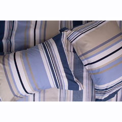 Jogo de lençol Super King em tons de azul e bege, com travesseiros estampados em listras sobre uma cama.