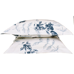 Almofadas com estampa de folhas em azul sobre fundo claro.