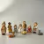 Conjunto de figuras representando o nascimento de Jesus, incluindo personagens como Maria, José, pastores e animais.