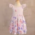 Vestido infantil rosa claro com estampa de borboletas em tons de rosa e lilás, com mangas curtas bufantes